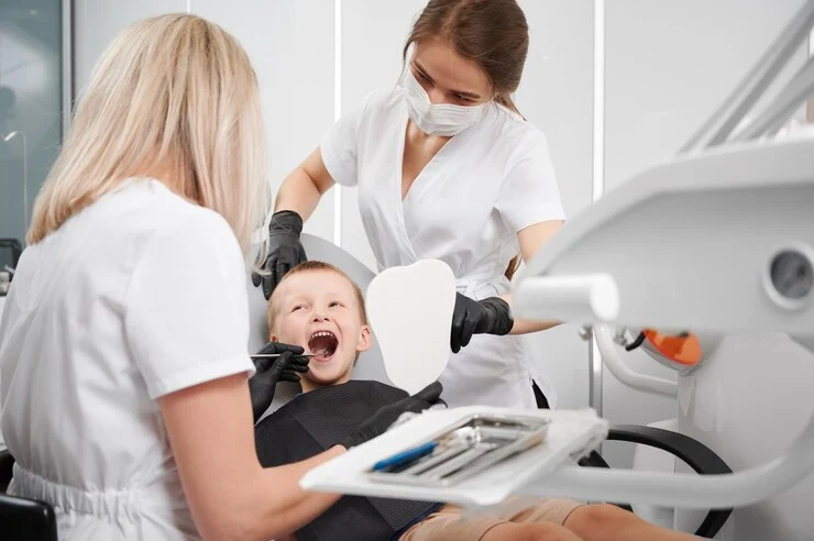 tannlegeassistent som undersøker barnets tenner tannlegekontor
